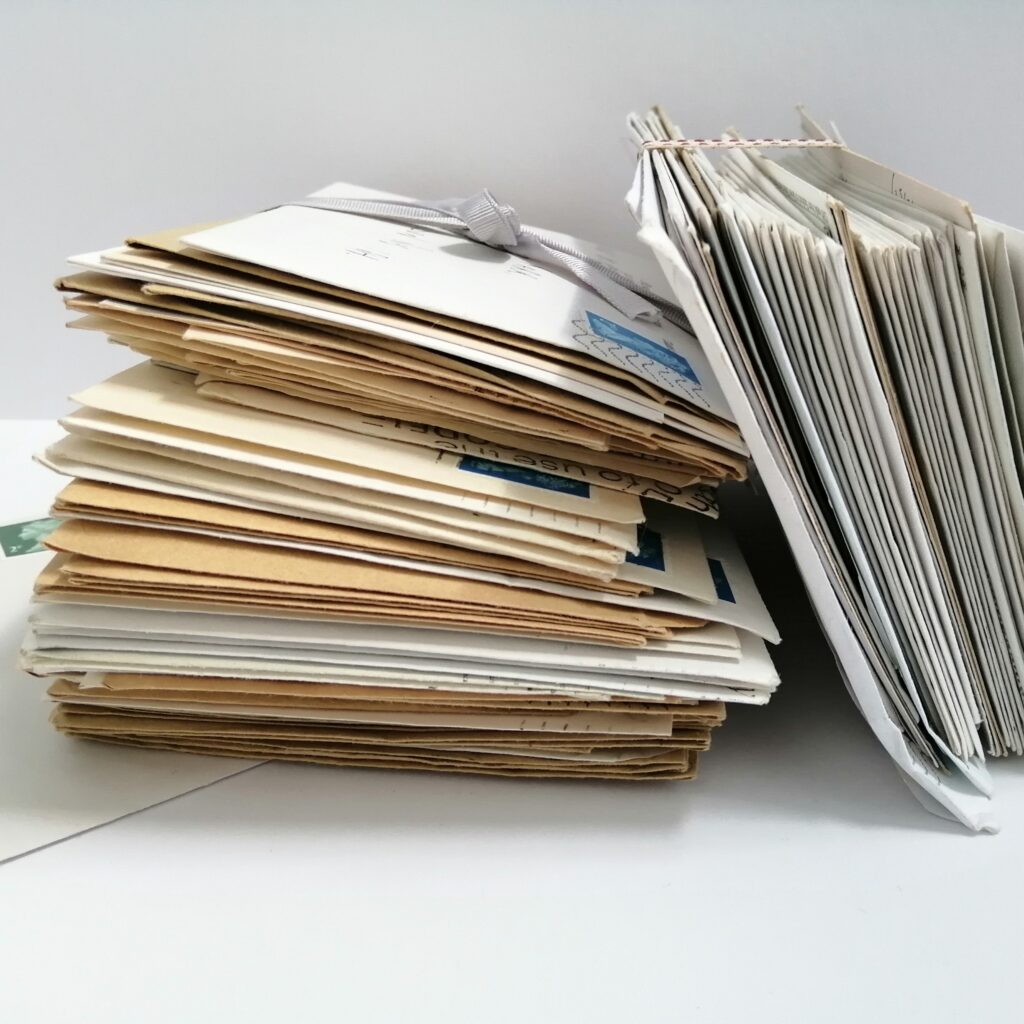 Photograph of bundles of letters, colouring with age, tied with ribbons.
